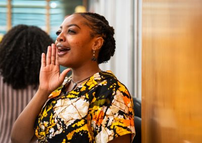 Community members in formal attire laughing and connecting around decorated tables at the Community Gala 2025.