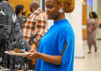 Community members in formal attire laughing and connecting around decorated tables at the Community Gala 2025.