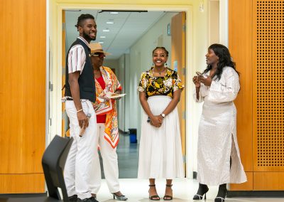 Community members in formal attire laughing and connecting around decorated tables at the Community Gala 2025.