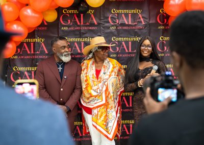 Community members in formal attire laughing and connecting around decorated tables at the Community Gala 2025.