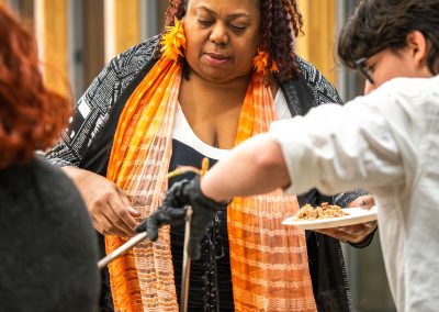 Community members in formal attire laughing and connecting around decorated tables at the Community Gala 2025.