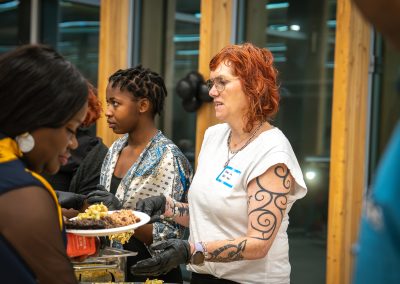 Community members in formal attire laughing and connecting around decorated tables at the Community Gala 2025.