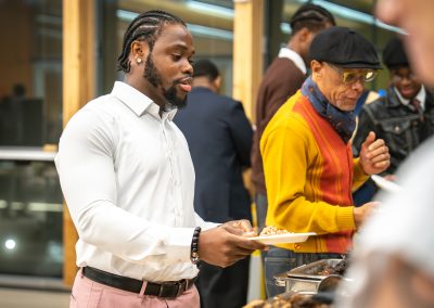 Community members in formal attire laughing and connecting around decorated tables at the Community Gala 2025.