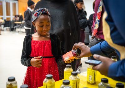Community members in formal attire laughing and connecting around decorated tables at the Community Gala 2025.