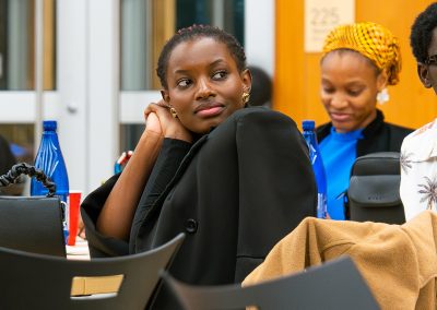 Community members in formal attire laughing and connecting around decorated tables at the Community Gala 2025.