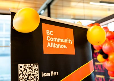 Community members in formal attire laughing and connecting around decorated tables at the Community Gala 2025.