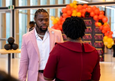 Community members in formal attire laughing and connecting around decorated tables at the Community Gala 2025.