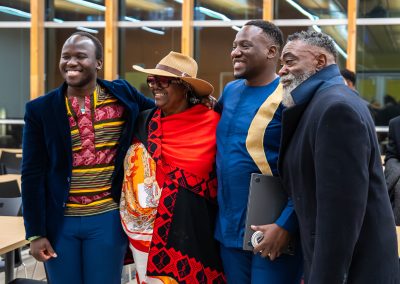 Community members in formal attire laughing and connecting around decorated tables at the Community Gala 2025.