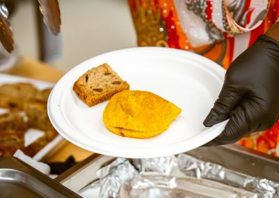 Community members in formal attire laughing and connecting around decorated tables at the Community Gala 2025.