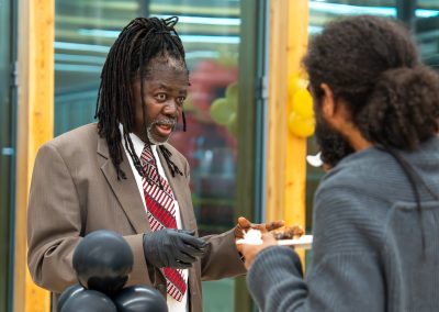Community members in formal attire laughing and connecting around decorated tables at the Community Gala 2025.