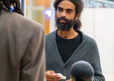Community members in formal attire laughing and connecting around decorated tables at the Community Gala 2025.