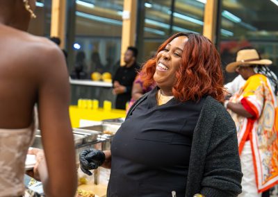 Community members in formal attire laughing and connecting around decorated tables at the Community Gala 2025.