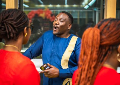 Community members in formal attire laughing and connecting around decorated tables at the Community Gala 2025.