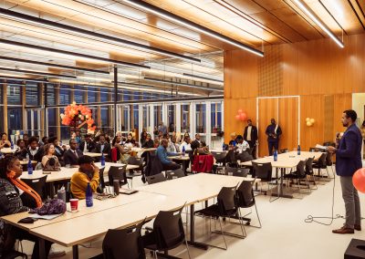Community members in formal attire laughing and connecting around decorated tables at the Community Gala 2025.
