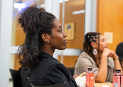 Community members in formal attire laughing and connecting around decorated tables at the Community Gala 2025.