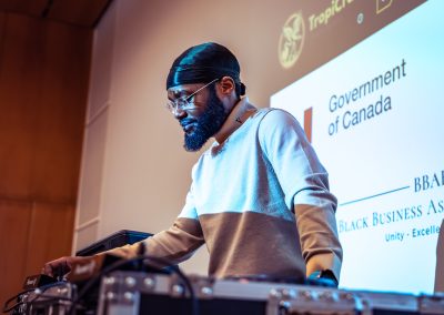 Community members in formal attire laughing and connecting around decorated tables at the Community Gala 2025.