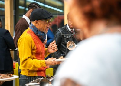 Community members in formal attire laughing and connecting around decorated tables at the Community Gala 2025.