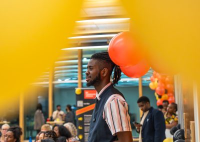 Community members in formal attire laughing and connecting around decorated tables at the Community Gala 2025.