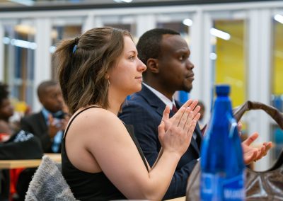 Community members in formal attire laughing and connecting around decorated tables at the Community Gala 2025.