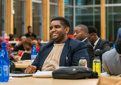 Community members in formal attire laughing and connecting around decorated tables at the Community Gala 2025.