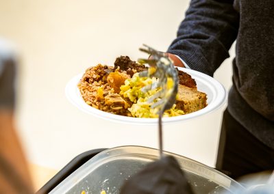 Community members in formal attire laughing and connecting around decorated tables at the Community Gala 2025.
