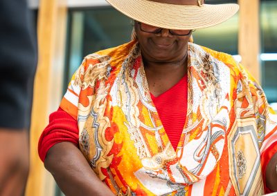 Community members in formal attire laughing and connecting around decorated tables at the Community Gala 2025.