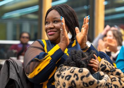 Community members in formal attire laughing and connecting around decorated tables at the Community Gala 2025.