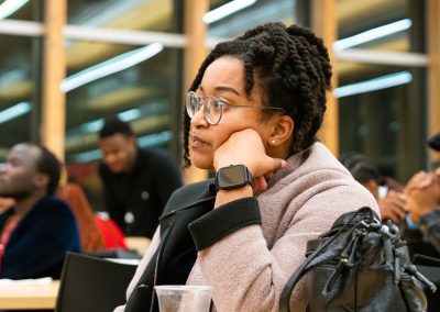 Community members in formal attire laughing and connecting around decorated tables at the Community Gala 2025.