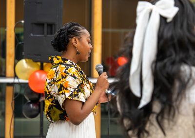 Community members in formal attire laughing and connecting around decorated tables at the Community Gala 2025.
